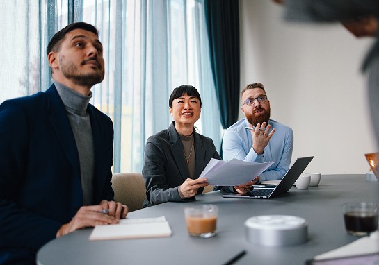 A group of people seated around a table, for a collaborative work session.
